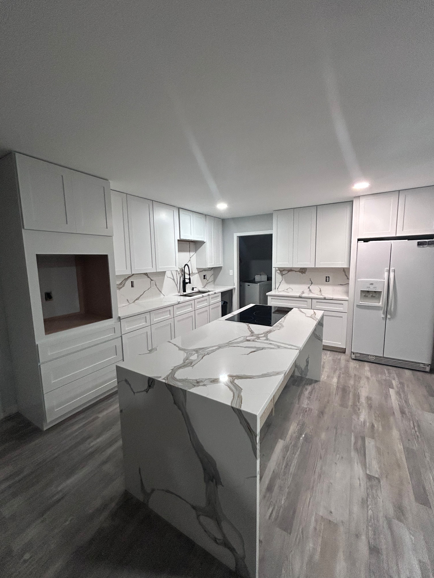 White kitchen with calacatta-look waterfall island